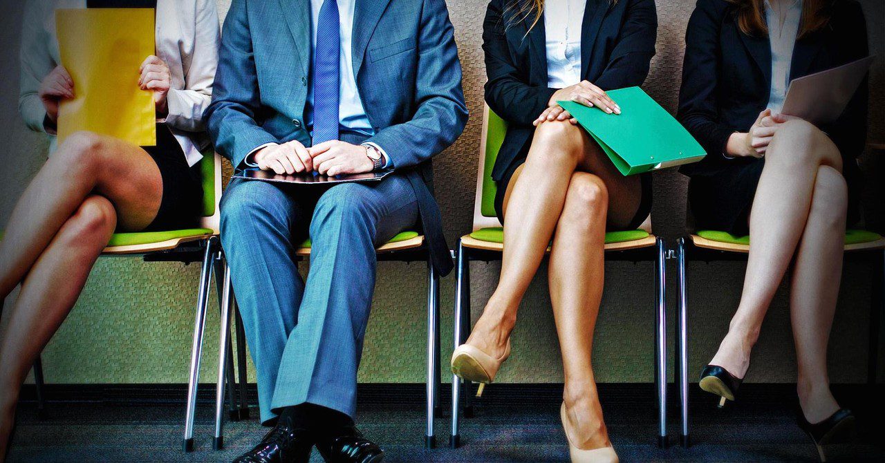 A képen állásinterjúra váró jelentkezők üllnek egymás mellett.