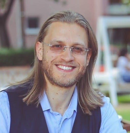 Ábry Zoltán portréja, kék ingben, fekete mellényben mosolyog, a háttér elmosódott.