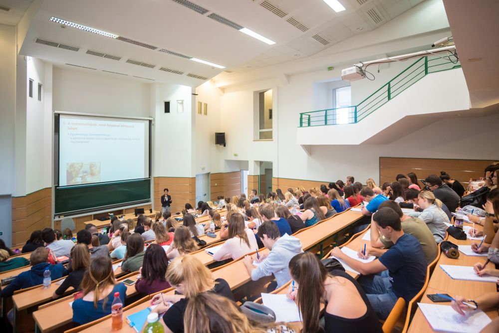 A Pannon Egyetem Polinszky előadóterme, lépcsőzetes padsorokkal és vetítővászonnal.
